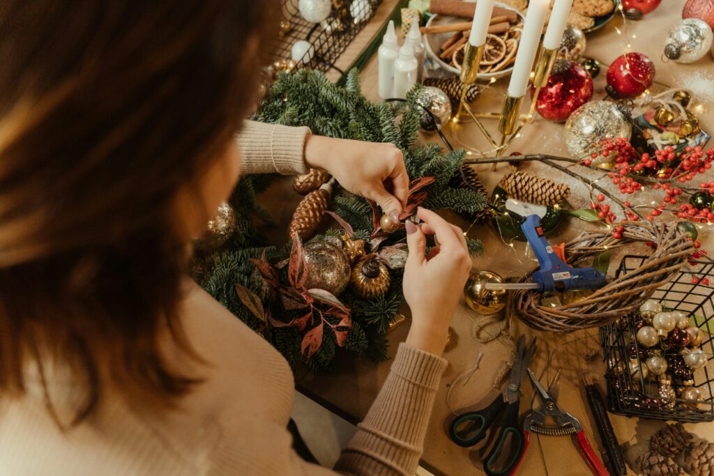 a person making christmas decorations