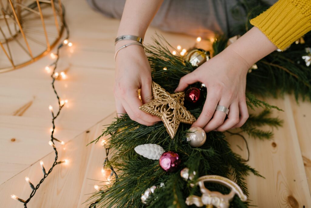 a person holding a christmas wreath