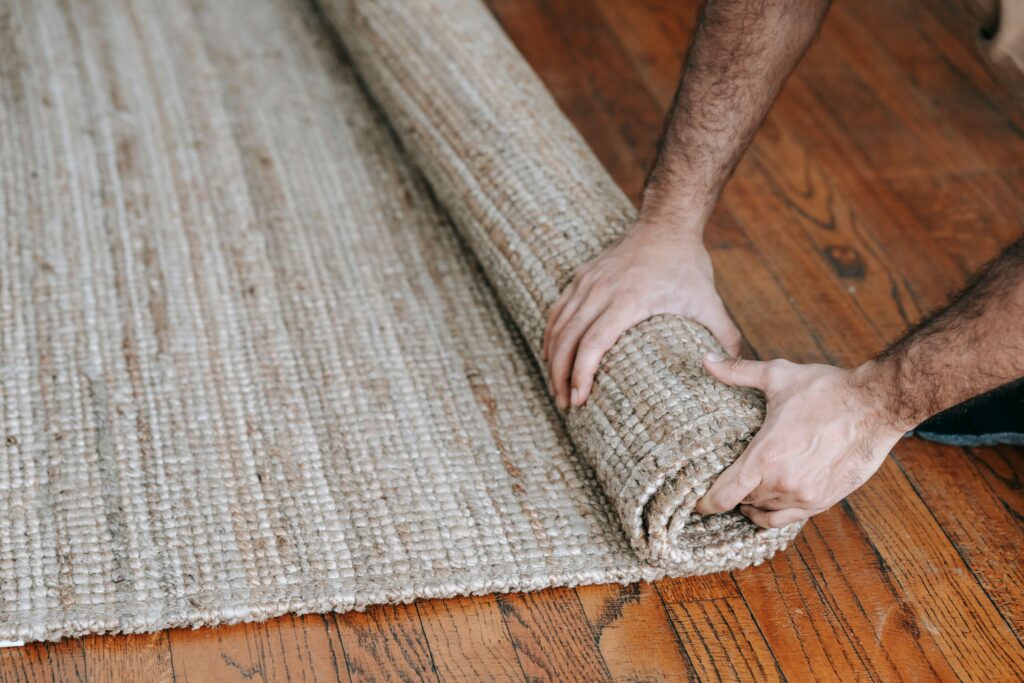a person rolling up a carpet